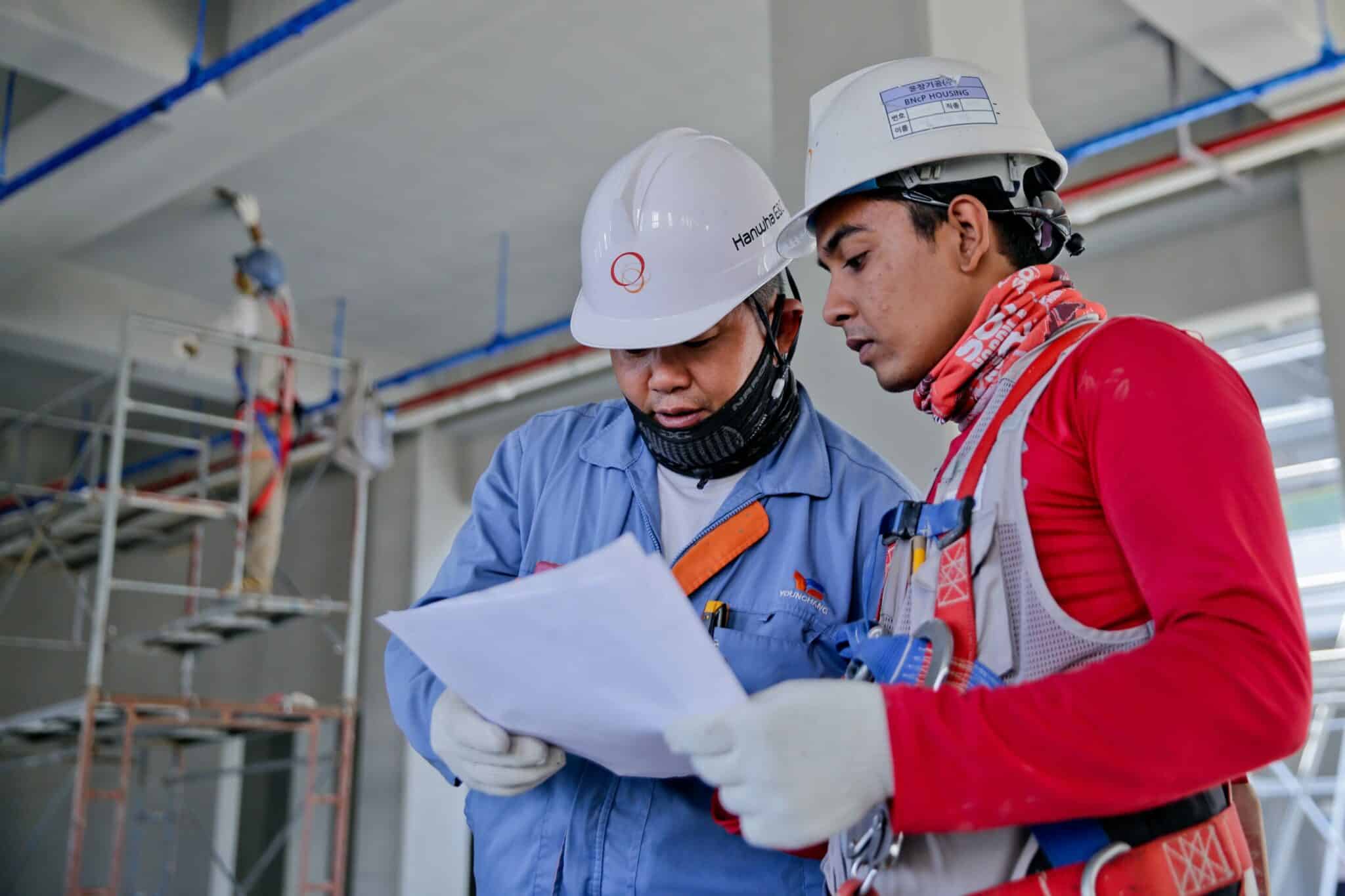 Image of two construction workers looking at build plans